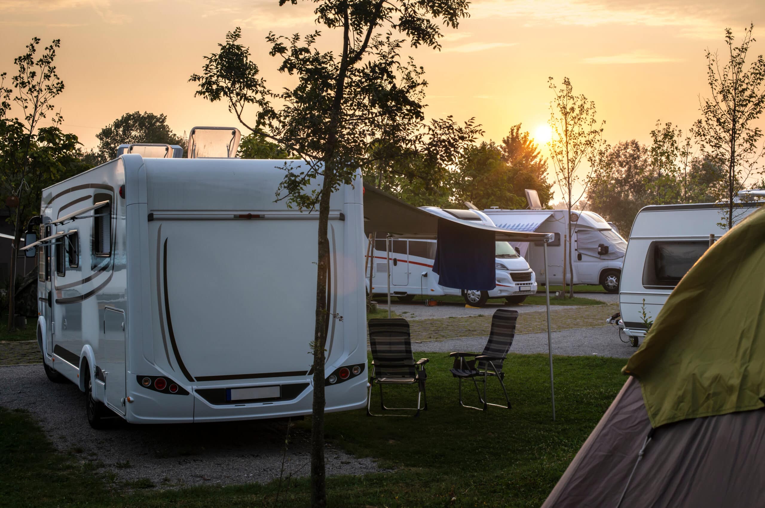 Caravans and campers on green meadow in campsite. Sunrise, rays cost segregation analysis for a campground in Farmington, Pennsylvania